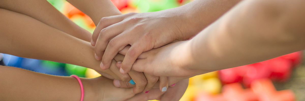 Teens stacking hands